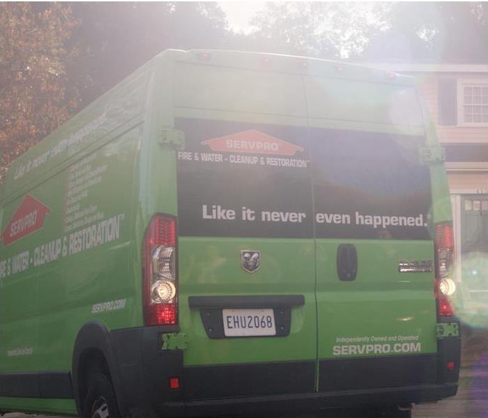 green SERVPRO van in front of a yellow house