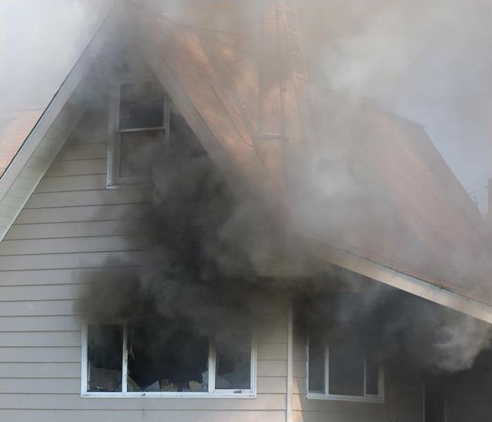 smoke coming out of the window of a 2nd story house