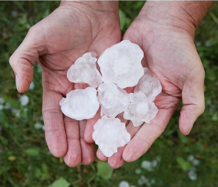 Large chunks of hail in a persons hand